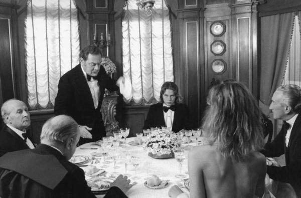Scena del film "Oh! Serafina" - Regia Alberto Lattuada - 1976 - Gli attori Ettore Manni e Dalila Di Lazzaro, nuda, a tavola con attori non identificati