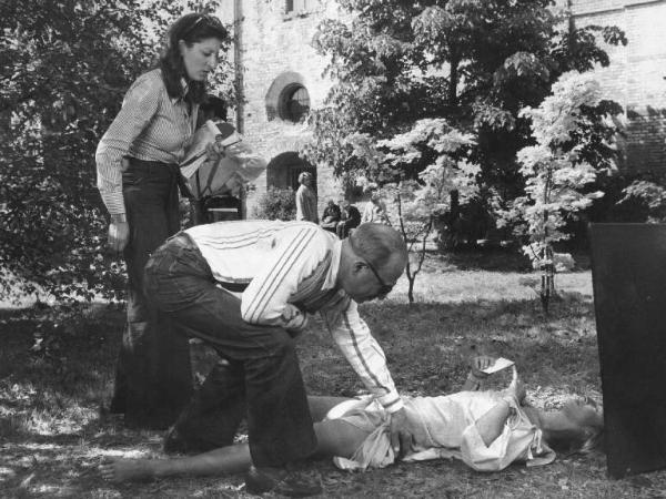 Set del film "Oh! Serafina" - Regia Alberto Lattuada - 1976 - Il regista Alberto Lattuada e l'attrice Dalila Di Lazzaro stesa sul prato