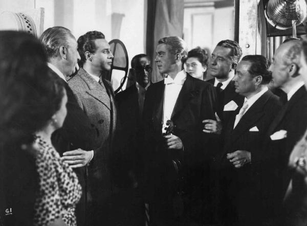 Scena del film "Amanti senza amore" - Regia Gianni Franciolini - 1947 - Gli attori Roldano Lupi e Jean Servais, con un violino, e attori non identificati