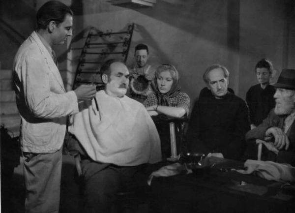 Scena del film "Un americano in vacanza" - Regia Luigi Zampa - 1945 - Gli attori Valentina Cortese e Giovanni Dolfini, in veste da prete, osservano un barbiere che taglia la barba a un attore non identificato
