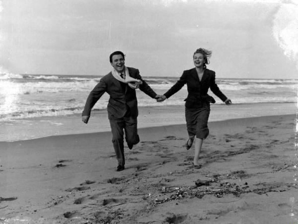 Scena del film "Le amiche" - Regia Michelangelo Antonioni - 1955 - Gli attori Franco Fabrizi e Yvonne Furneaux corrono sulla spiaggia vicino al mare
