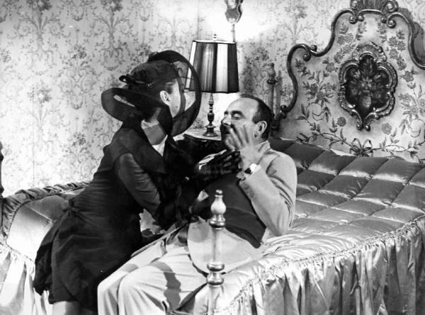 Scena del film "Amore facile" - Regia Gianni Puccini - 1964 - L'attore Vittorio Caprioli e un'attrice non identificata sul letto