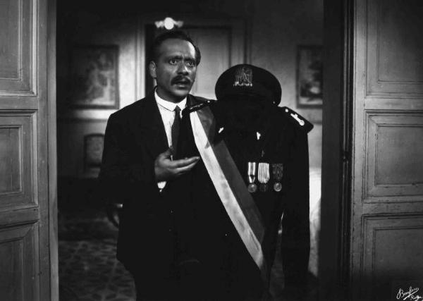 Scena del film "Anni difficili" - Regia Luigi Zampa - 1948 - L'attore Umberto Spadaro tiene in mano una divisa da camerata fascista