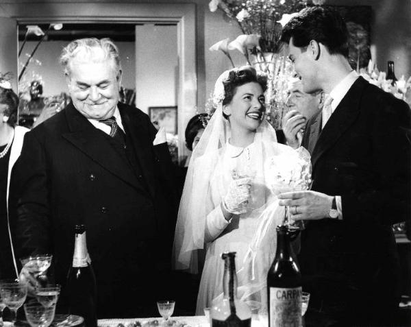 Scena del film "Anni facili" - Regia Luigi Zampa - 1953 - Gli attori Giovanna Ralli, in abito da sposa, e Gabriele Tinti brindano per il loro matrimonio tra attori non identificati