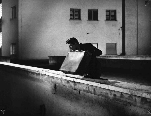 Scena del film "Audace colpo dei soliti ignoti" - Regia Nanni Loy - 1959 - L'attore Vittorio Gassman sul tetto con una valigia