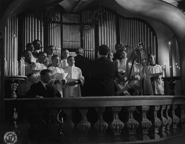 Scena del film "Ave Maria" - Regia Johannes Riemann - 1936 - Un coro di chierichetti e un organista diretti da un maestro di musica in chiesa