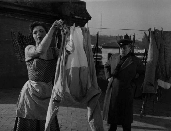 Scena del film "La banda degli onesti" - Regia Camillo Mastrocinque - 1956 - L'attore Totò e un'attrice non identificata che stende i panni sul tetto
