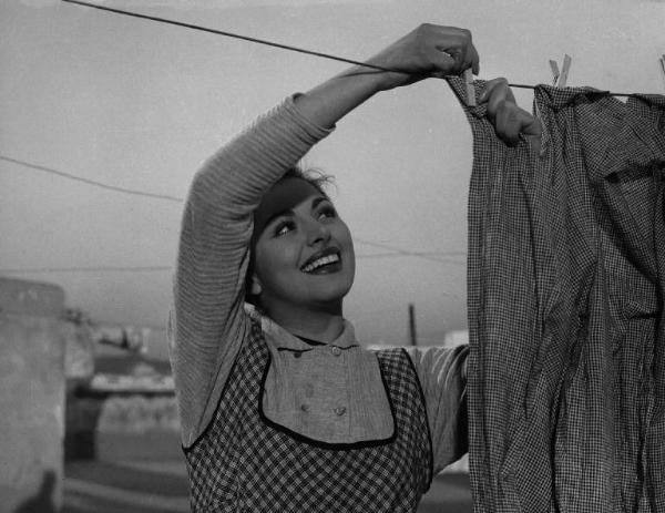 Scena del film "La banda degli onesti" - Regia Camillo Mastrocinque - 1956 - Un'attrice non identificata stende i panni sul tetto