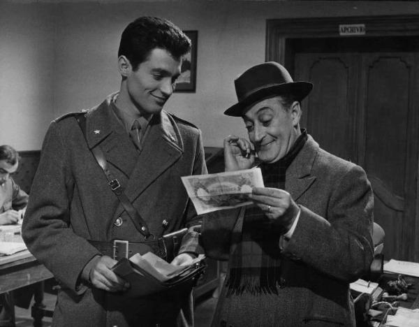 Scena del film "La banda degli onesti" - Regia Camillo Mastrocinque - 1956 - Gli attori Gabriele Tinti e Totò che osserva una banconota da diecimila lire