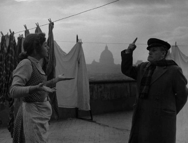 Scena del film "La banda degli onesti" - Regia Camillo Mastrocinque - 1956 - L'attore Totò e un'attrice non identificata che stende i panni sul tetto