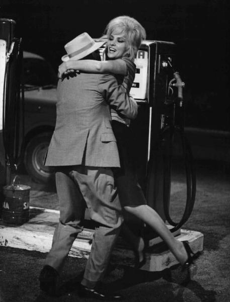 Scena del film "La bellezza d'Ippolita" - Giancarlo Zagni - 1962 - Gli attori Gina Lollobrigida e Franco Balducci accanto a un distributore di benzina