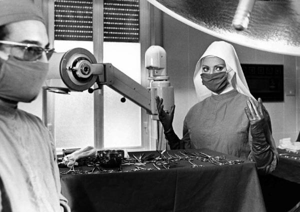 Scena del film "Bianco, rosso, e..." - Alberto Lattuada - 1972 - Il regista Alberto Lattuada e l'attrice Sophia Loren in camice in sala operatoria di un ospedale