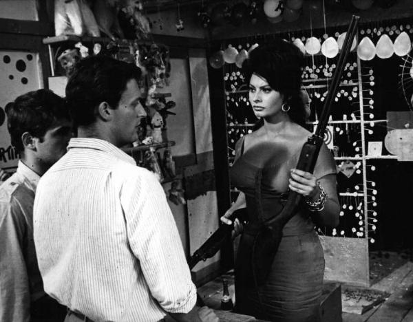 Scena dell'episodio "La riffa" del film "Boccaccio '70" - Regia Vittorio De Sica - 1962 - L'attrice Sophia Loren con fucile e attori non identificati