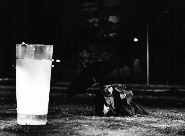 Scena dell'episodio "Le tentazioni del dottor Antonio" del film "Boccaccio '70" - Regia Federico Fellini - 1962 - L'attore Peppino De Filippo steso a terra con un ombrello tende la mano verso un bicchiere di latte