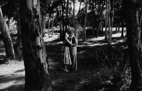 Scena del film "Bufere" - Guido Brignone - 1953 - Gli attori Silvana Pampanini e Jean Gabin abbracciati in un parco