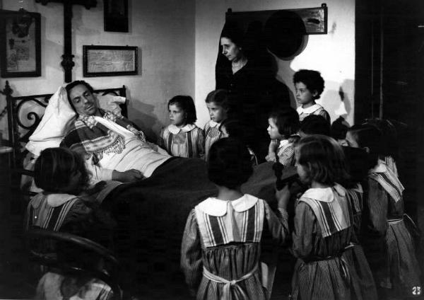 Scena del film "Campane a martello" - Luigi Zampa - 1949 - L'attore Eduardo De Filippo a letto circandato da un gruppo di bambine