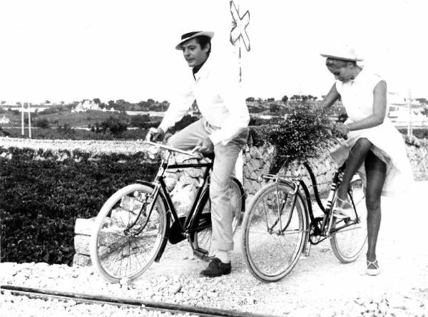 Scena del film "Casanova '70" - Regia Mario Monicelli - 1964 - Gli attori Marcello Mastroianni e Virna Lisi in bicicletta