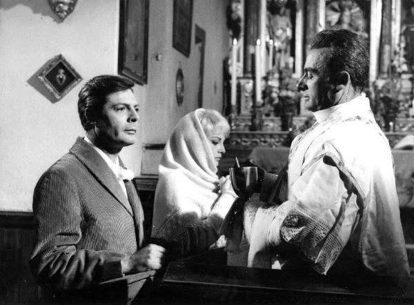 Scena del film "Casanova '70" - Regia Mario Monicelli - 1964 - Gli attori Marcello Mastroianni e Virna Lisi in chiesa ricevono l'ostia da un prete