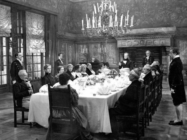 Scena del film "Casta diva" - Regia Carmine Gallone - 1935 - L'attore Sandro Palmieri e attori non identificati a tavola