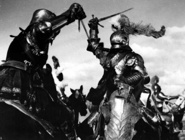 Scena del film "Il cavaliere senza nome" - Regia Ferruccio Cerio - 1941 - Due attori non identificati in armatura a cavallo combattono a colpi di spade