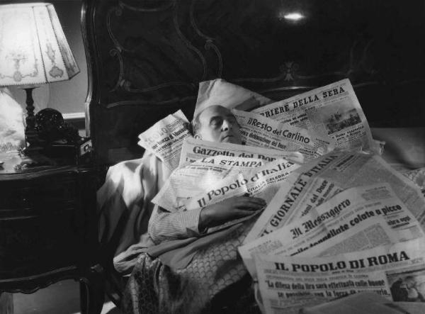 Scena del film "Cercasi Bionda Bella Presenza" - Regia Pina Renzi - 1942 - L'attore Luigi Almirante steso sul letto e ricoperto dai quotidiani