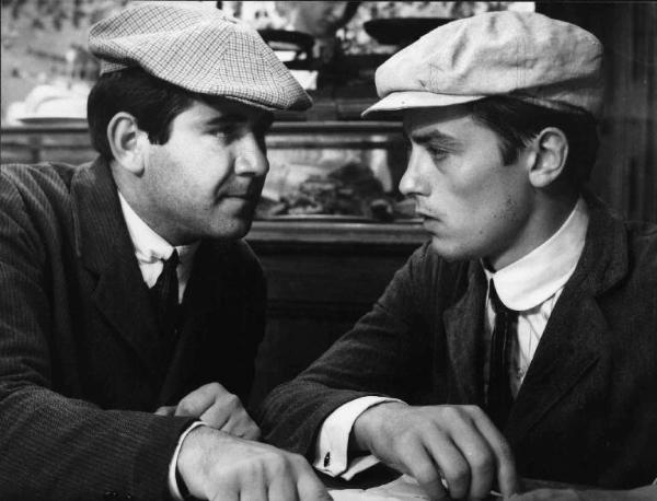 Scena del film "Che gioia vivere" - Regia René Clément - 1961 - Un attore non identificato e l'attore Alain Delon parlano a un tavolo