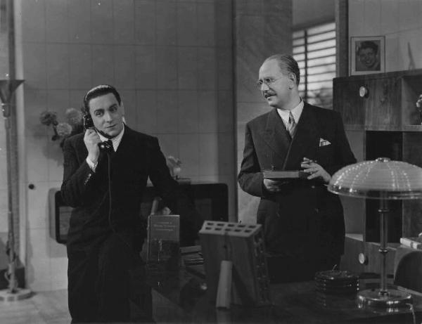 Scena del film "Chi è più felice di me?" - Regia Guido Brignone - 1938 - L'attore Tito Schipa e un attore non identificato in ufficio
