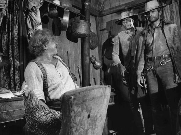 Scena del film "La collina degli stivali" - Regia Giuseppe Colizzi - 1969 - Gli attori Lionel Stander, Leslie Bailey e Terence Hill si guardano in piedi in una stanza