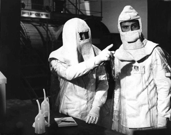 Scena del film "Un colpo da mille miliardi" - Regia Paolo Heusch - 1966 - Due attori non identificati indossano una tuta per esperimenti in laboratorio