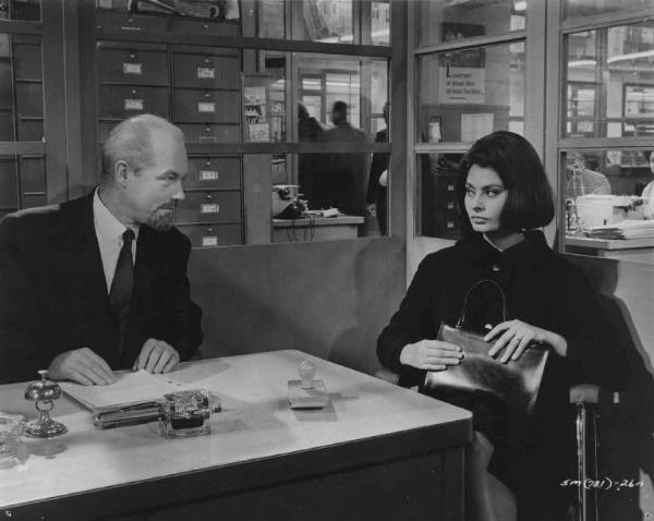 Scena del film "Il coltello nella piaga" - Regia Anatole Litvak - 1962 - Un attore non identificato e l'attrice Sophia Loren seduti in un interno.