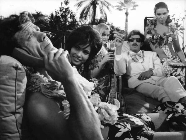 Scena del film "Come rubammo la bomba atomica" - Regia Lucio Fulci - 1967 - Gli attori Franco Franchi e Ciccio Ingrassia si rilassano circondati da attrici non identificate