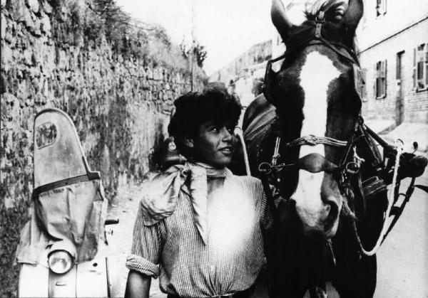 Scena del film "La commare secca" - Regia Bernardo Bertolucci - 1962 - Un giovane attore non identificato porta un cavallo.