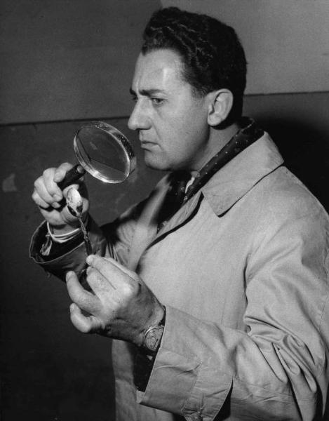 Scena del film "Il Commissario" - Regia Luigi Comencini - 1962 - L'attore Alberto Sordi ispeziona un cucchiaino con la lente di ingrandimento