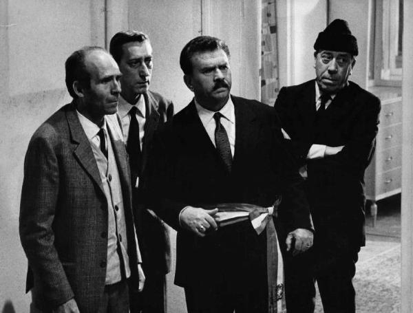 Scena del film "Il Compagno Don Camillo" - Regia Luigi Comencini - 1965 - Due attori non identificati e gli attori Gino Cervi e Fernandel in piedi in una stanza