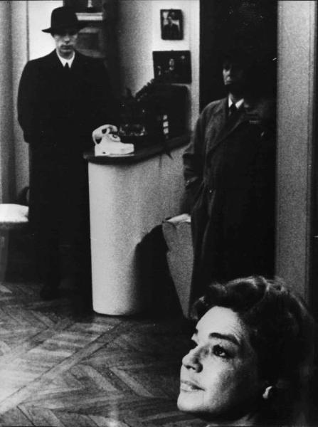 Scena del film "La Confessione" - Regia Constantin Costa-Gavras - 1970 - Due attori non identificati alle spalle dell'attrice Simone Signoret