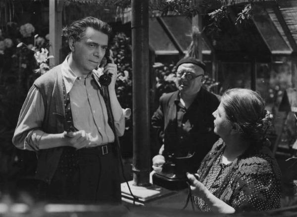 Scena del film "Confessione" - Regia Flavio Calzavara - 1941 - L'attore Aldo Silvani al telefono, vicino a due attori non identificati