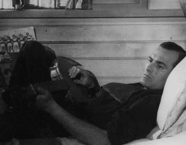 Scena del film "Confessione" - Regia Flavio Calzavara - 1941 - L'attore Friedrich Benfer suona la chitarra, steso sul letto