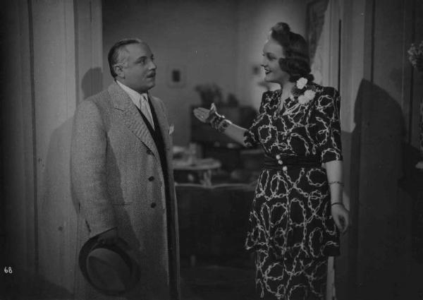 Scena del film "Con le donne non si scherza" - Regia Giorgio Simonelli - 1941- L'attore Carlo Campanini e l'attrice Greta Gonda in piedi in una stanza