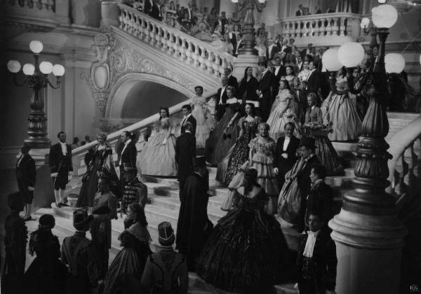 Scena del film "La Contessa Castiglione" - Regia Flavio Calzavara - 1942 - Attori non identificati, elegantemente vestiti, scendono lo scalone di un palazzo