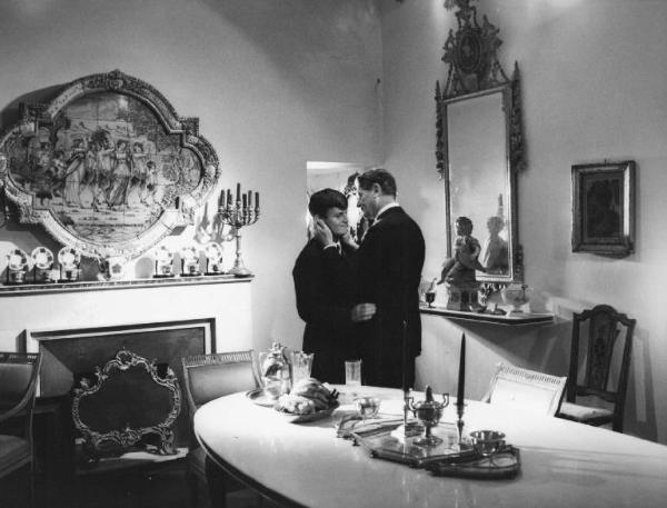 Set del film "La Corruzione" - Regia Mauro Bolognini- 1964- L'attore Jacques Perrin e l'attore Alain Cuny abbracciati in una sala da pranzo.