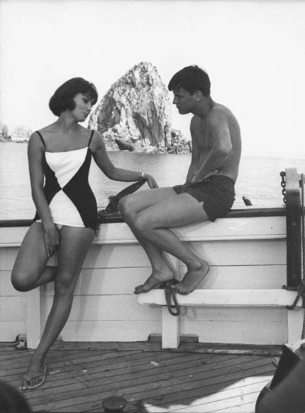 Set del film "La Corruzione" - Regia Mauro Bolognini- 1964- L'attore Jacques Perrin e l'attrice Rosanna Schiaffino parlano appoggiati al bordo di una barca.
