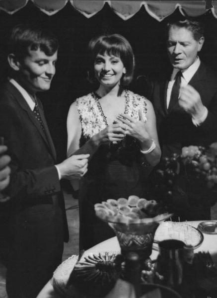Set del film "La Corruzione" - Regia Mauro Bolognini- 1964- L'attore Jacques Perrin, la sorridente attrice Rosanna Schiaffino e l'attore Alain Cuny in piedi davanti ad un tavolo imbandito.