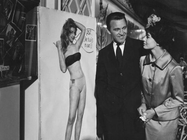 Set del film "Costa azzurra" - Regia Vittorio Sala - 1959- L'attore Franco Fabrizi e l'attrice Giovanna Ralli guardano un poster.