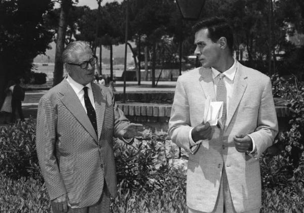 Set del film "Costa azzurra" - Regia Vittorio Sala - 1959- Due attori non identificati parlano in un parco.