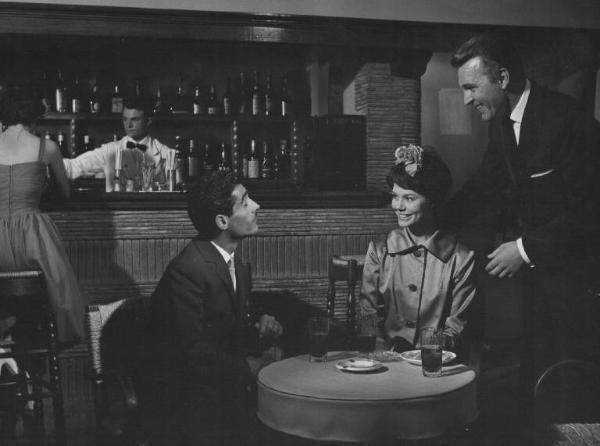 Set del film "Costa azzurra" - Regia Vittorio Sala - 1959- Un attore non identificato, l'attrice Giovanna Ralli e l'attore Franco Fabrizi intorno ad un tavolo in un bar.