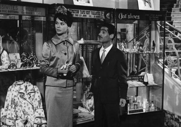 Set del film "Costa azzurra" - Regia Vittorio Sala - 1959- L'attrice Giovanna Ralli e un attore non identificato davanti a delle vetrine.