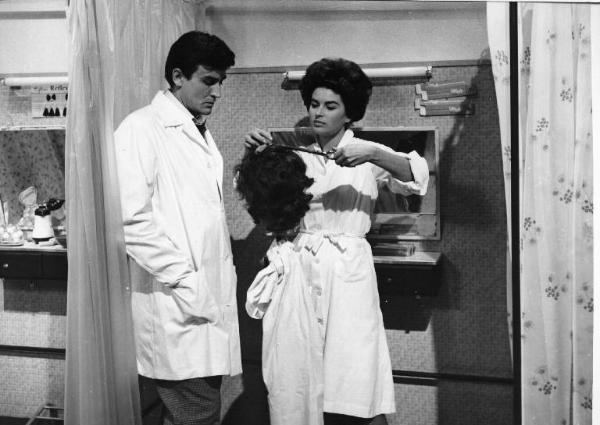 Set del film "Crimen" - Regia Mario Camerini- 1960 - L'attore Vittorio Gassman guarda l'attrice Silvana Mangano che taglia i capelli di una parrucca.