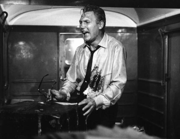 Set del film "Il criminale" - Regia Marcello Baldi- 1962 - L'attore Jack Palance piange ferito davanti ad una valigia in uno scompartimento.