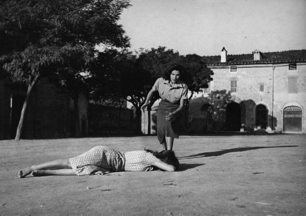 Set del film "Il Cristo proibito" - Regia Curzio Malaparte- 1950 - L'attrice Elena Varzi corre verso l'attrice Anna Maria Ferrero, sdraiata in mezzo ad un cortile.
