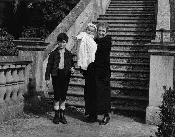 Set del film "Cronaca familiare" - Regia Valerio Zurlini 1962 - Una donna anziana con due bambini davanti alla scalinata esterna di un edificio.